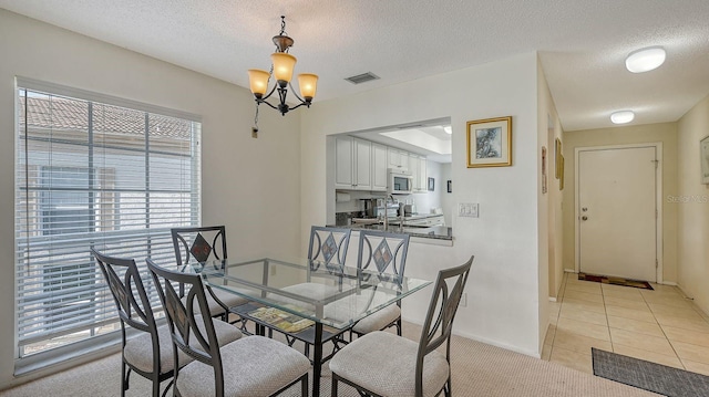 dining room with light tile patterned floors, a textured ceiling, and a notable chandelier