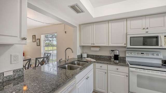 kitchen featuring white cabinets, dark stone countertops, white appliances, and sink