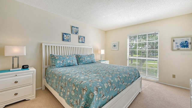 bedroom featuring light carpet, a textured ceiling, and multiple windows