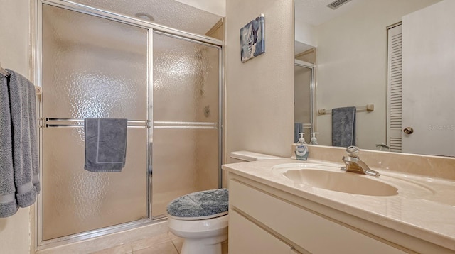 bathroom with tile patterned flooring, a textured ceiling, an enclosed shower, toilet, and vanity