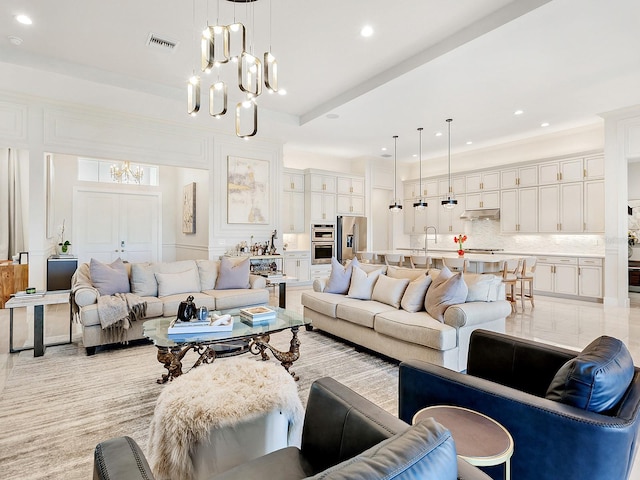 living room featuring sink and a chandelier