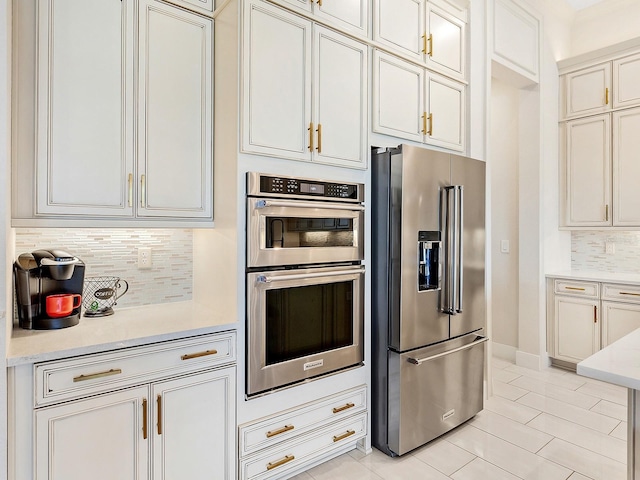 kitchen featuring decorative backsplash, light tile patterned floors, and stainless steel appliances