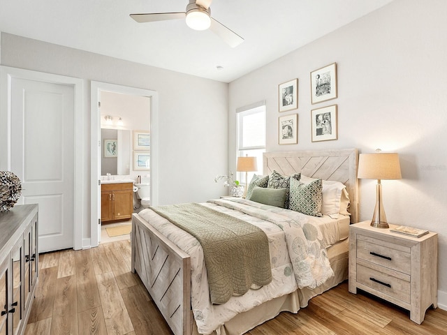 bedroom featuring ceiling fan, light wood-type flooring, sink, and connected bathroom