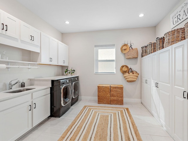 clothes washing area featuring cabinets, washing machine and dryer, light tile patterned floors, and sink