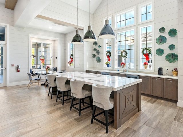 kitchen with a breakfast bar, light hardwood / wood-style flooring, and decorative light fixtures