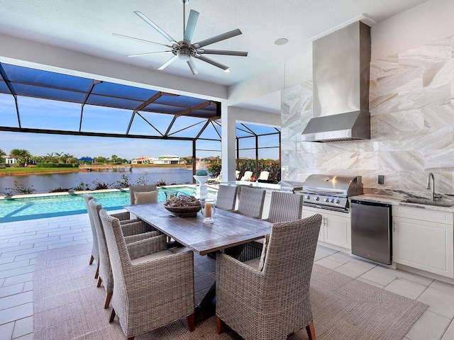 view of patio with glass enclosure, sink, exterior kitchen, grilling area, and a water view