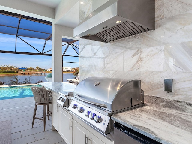 view of patio featuring an outdoor kitchen, a water view, a lanai, and a grill