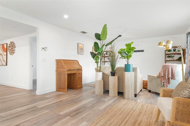 living room featuring ceiling fan and light hardwood / wood-style flooring