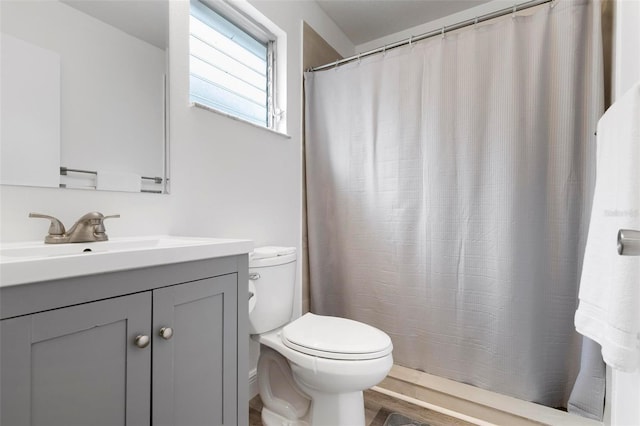 bathroom featuring vanity, curtained shower, and toilet