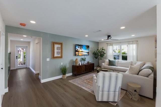 living room featuring ceiling fan and dark hardwood / wood-style flooring