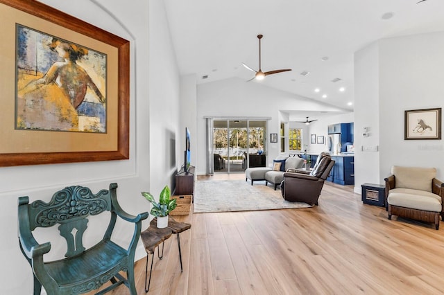 living room with light wood-type flooring, high vaulted ceiling, and ceiling fan