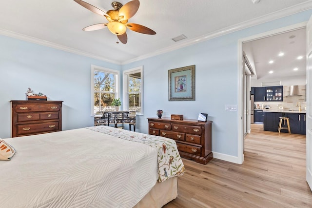 bedroom with light wood-type flooring, ceiling fan, ornamental molding, and sink