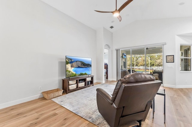 living room featuring high vaulted ceiling, light hardwood / wood-style floors, and ceiling fan