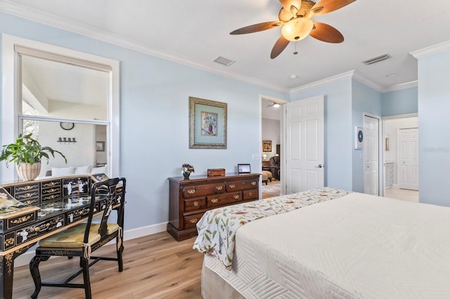 bedroom featuring light hardwood / wood-style flooring, ornamental molding, ceiling fan, and ensuite bathroom