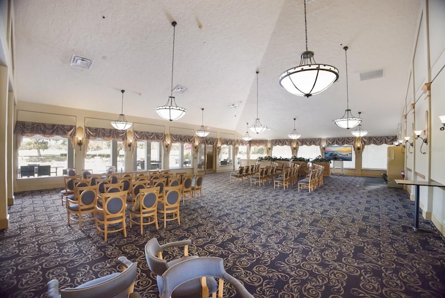 unfurnished dining area featuring high vaulted ceiling, a textured ceiling, and dark colored carpet