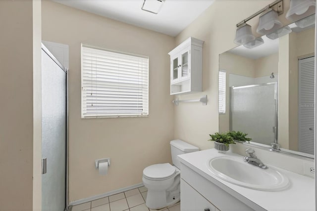 bathroom with tile patterned floors, vanity, toilet, and a shower with door