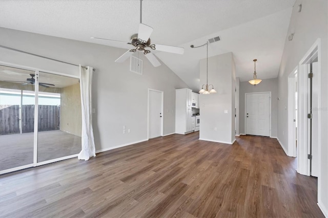 unfurnished living room featuring a textured ceiling, ceiling fan with notable chandelier, high vaulted ceiling, and dark wood-type flooring