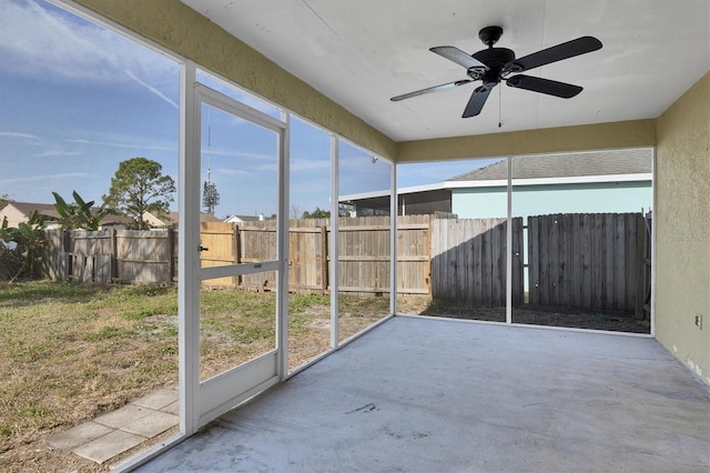 unfurnished sunroom with ceiling fan