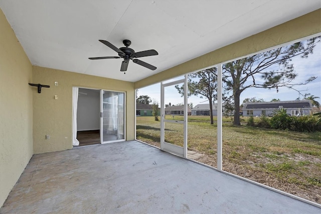 unfurnished sunroom with ceiling fan