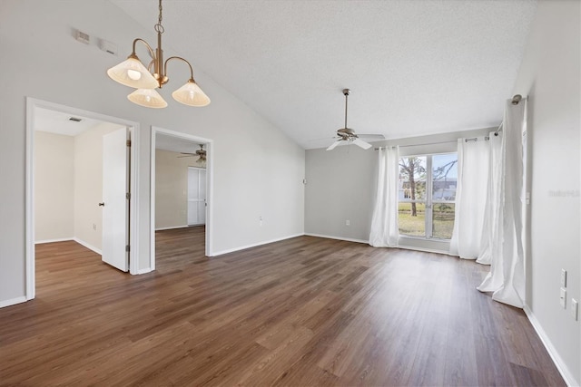 unfurnished dining area featuring a textured ceiling, dark hardwood / wood-style floors, lofted ceiling, and ceiling fan with notable chandelier