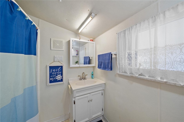 bathroom featuring vanity, a textured ceiling, walk in shower, and vaulted ceiling