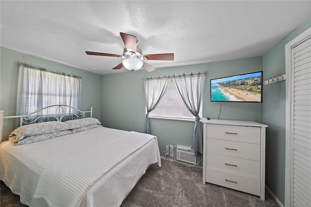 bedroom featuring dark colored carpet, ceiling fan, and a textured ceiling