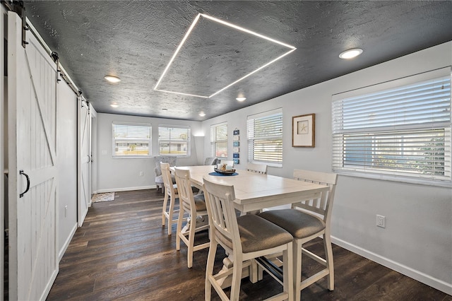 dining space with a barn door, a wealth of natural light, and dark wood-type flooring