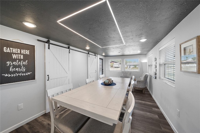 dining room with dark hardwood / wood-style floors, a barn door, and a textured ceiling