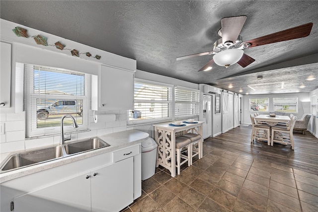 kitchen featuring white cabinetry, sink, and tasteful backsplash