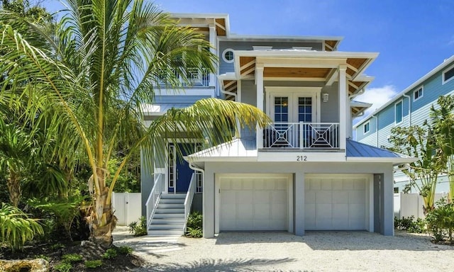 view of front of property featuring french doors, a balcony, and a garage