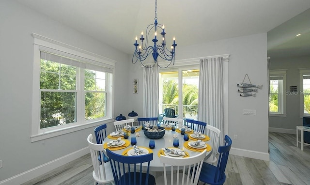 dining room featuring an inviting chandelier, a wealth of natural light, and light wood-type flooring