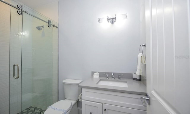 bathroom with vanity, a shower with shower door, and toilet