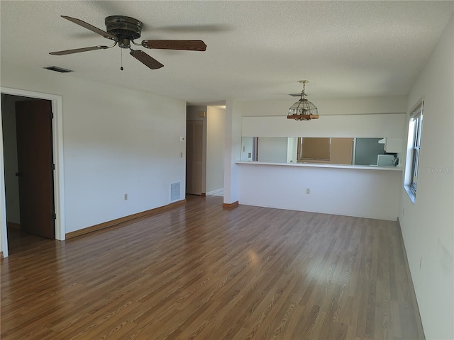 unfurnished living room featuring ceiling fan, a textured ceiling, and hardwood / wood-style flooring