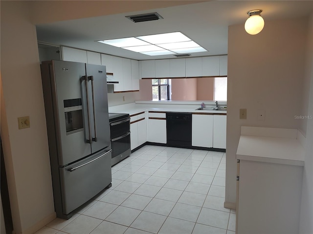 kitchen with light tile patterned flooring, sink, white cabinets, and black appliances