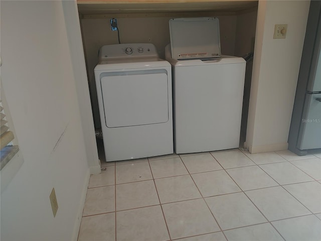 laundry area featuring washer and clothes dryer and light tile patterned floors