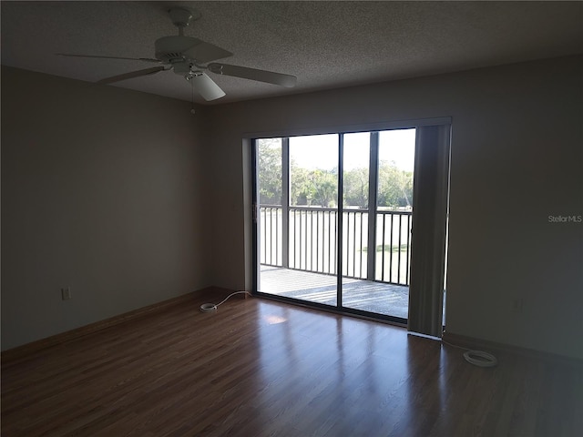 spare room featuring ceiling fan, dark hardwood / wood-style flooring, and a textured ceiling