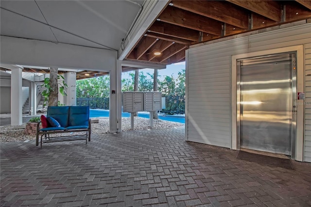 view of patio with elevator and a mail area