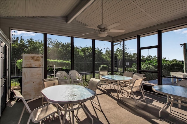 sunroom featuring ceiling fan and lofted ceiling with beams