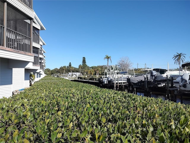 view of yard featuring a water view and a boat dock