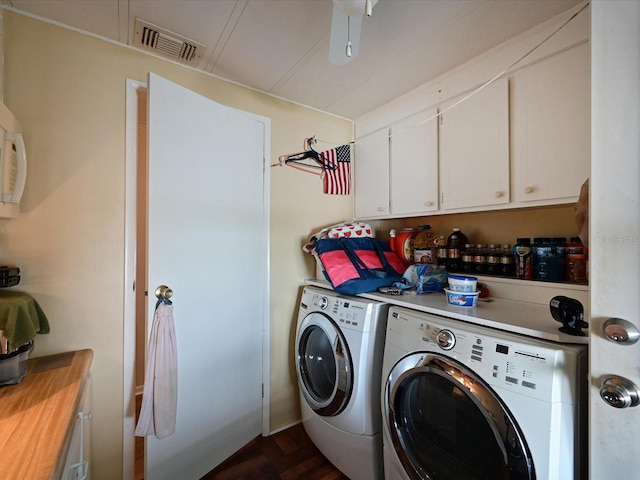 laundry room featuring washer and dryer, dark hardwood / wood-style floors, and cabinets