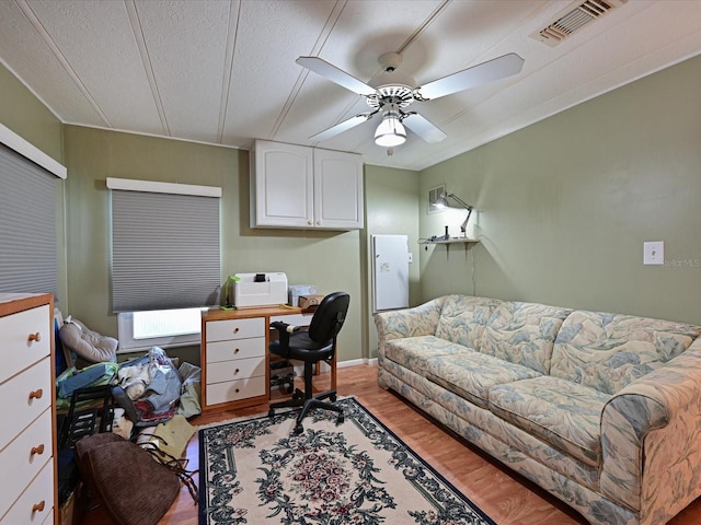 office area with a textured ceiling, light hardwood / wood-style floors, and ceiling fan