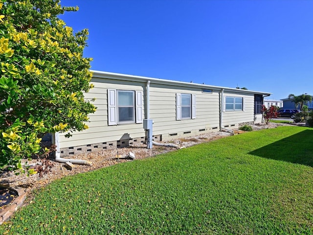 view of side of home with a yard