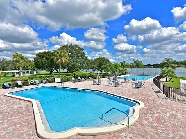 view of swimming pool with a patio and a water view