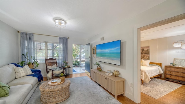 living room featuring a textured ceiling and light wood-type flooring