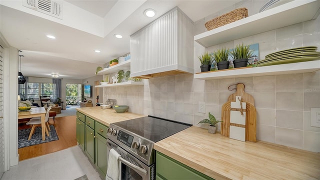 kitchen with butcher block countertops, light hardwood / wood-style floors, custom range hood, green cabinetry, and stainless steel electric range oven