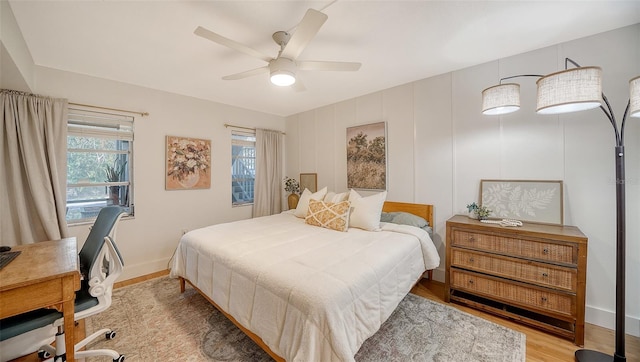 bedroom with multiple windows, ceiling fan, and light wood-type flooring