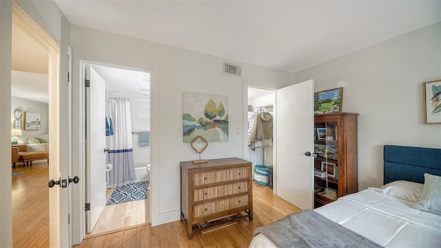 bedroom featuring ensuite bath, a closet, and light wood-type flooring