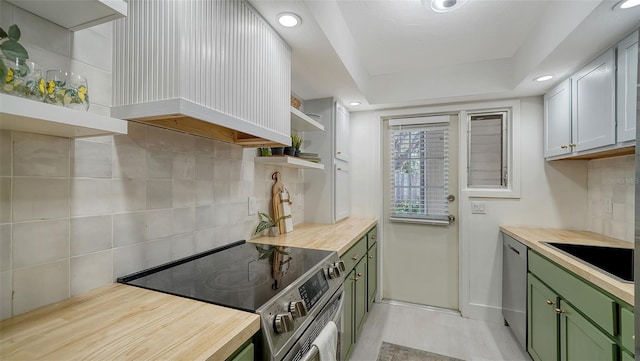 kitchen with sink, wooden counters, appliances with stainless steel finishes, custom range hood, and green cabinetry