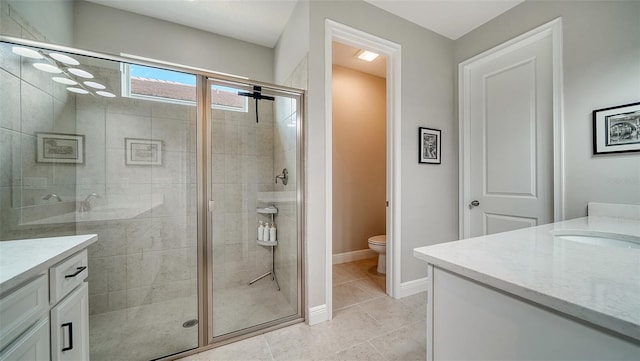 bathroom featuring tile patterned floors, vanity, and a shower with shower door