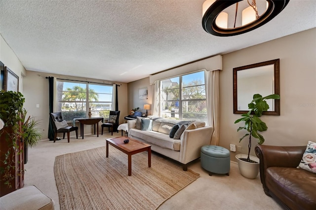 living room with a textured ceiling, light colored carpet, and a wealth of natural light